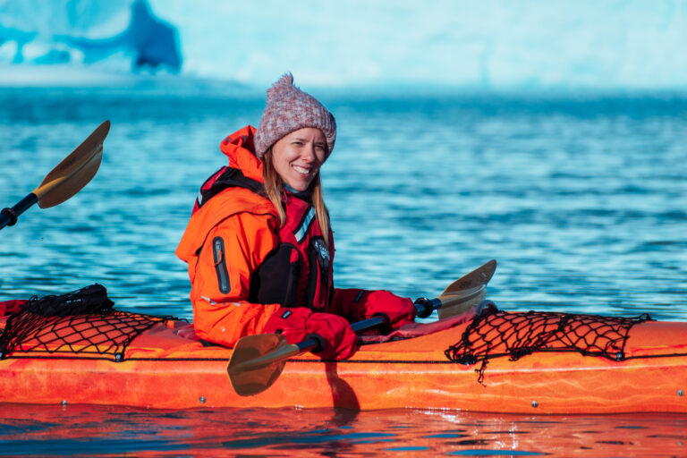 Woman kayaking near Perito Moreno Glacier.